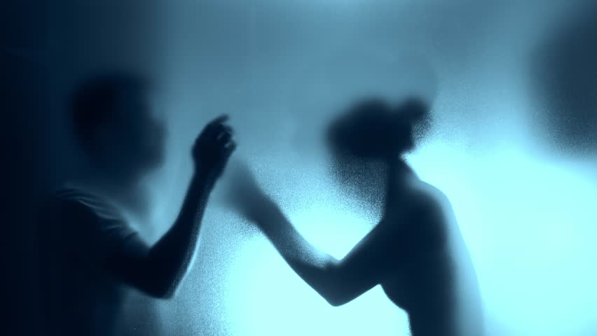 Couple arguing behind the frosted glass