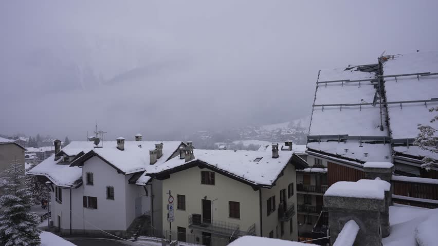 View of snow covered town centre and Church of Saint Pantalon in winter in Courmayeur, Aosta Valley, Italian Alps, Italy