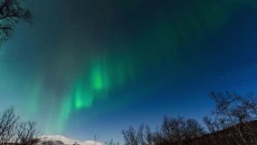 Northern lights glow above snowy hills in Finland, captured in a mesmerizing timelapse - Powered by Shutterstock - Get 15% off with code: PIKWIZARD15