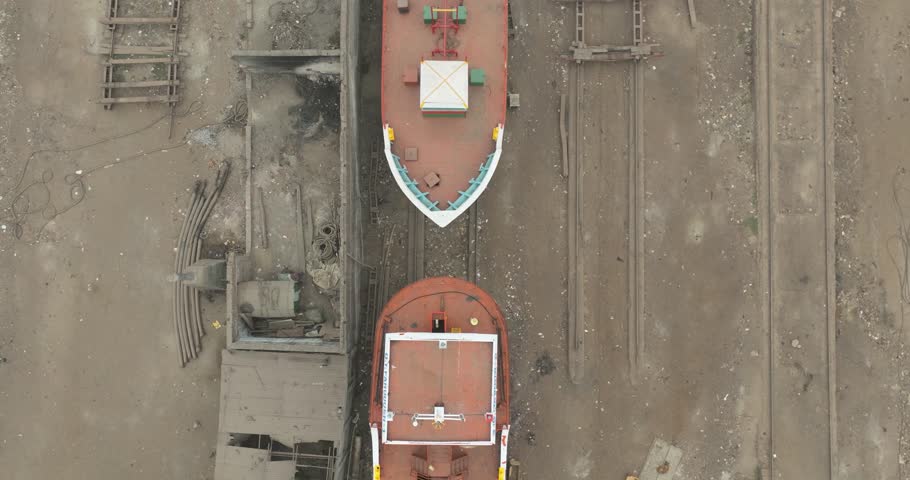 Aerial view of a busy shipyard with wooden boats and industrial buildings along the river, Dhaka, Dhaka Province, Bangladesh.