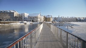 View of snow covered Tjornin Utsynisstaour park and city in background in winter, Reykjavik, Iceland - Powered by Shutterstock - Get 15% off with code: PIKWIZARD15