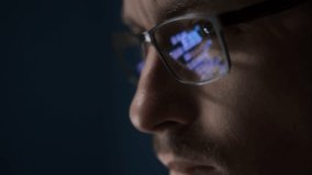Close up of focused software engineer or data scientist wearing glasses, analyzing code on his screen. Programming script reflects on his eyeglasses as he works late. - Powered by Shutterstock - Get 15% off with code: PIKWIZARD15