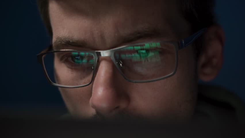 Close-up of a coder in glasses, intently working on a script. The reflection of programming code is visible on his eyeglasses as he develops an application. - Powered by Shutterstock - Get 15% off with code: PIKWIZARD15