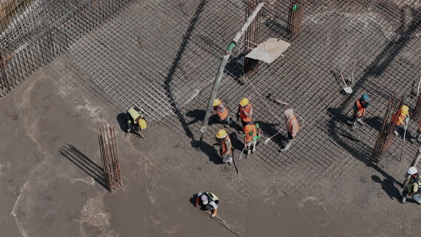 Workers pouring and leveling concrete foundation Aerial view 