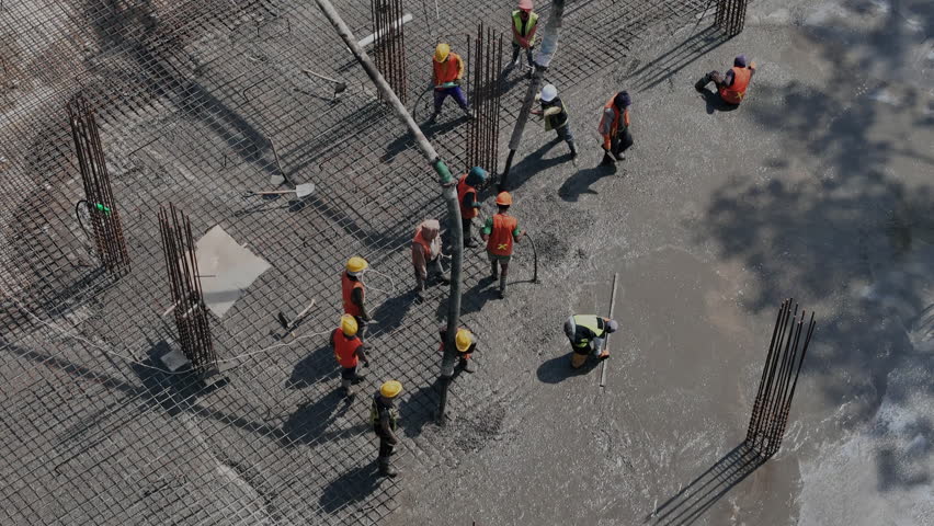 Workers pouring and leveling concrete foundation Aerial view 