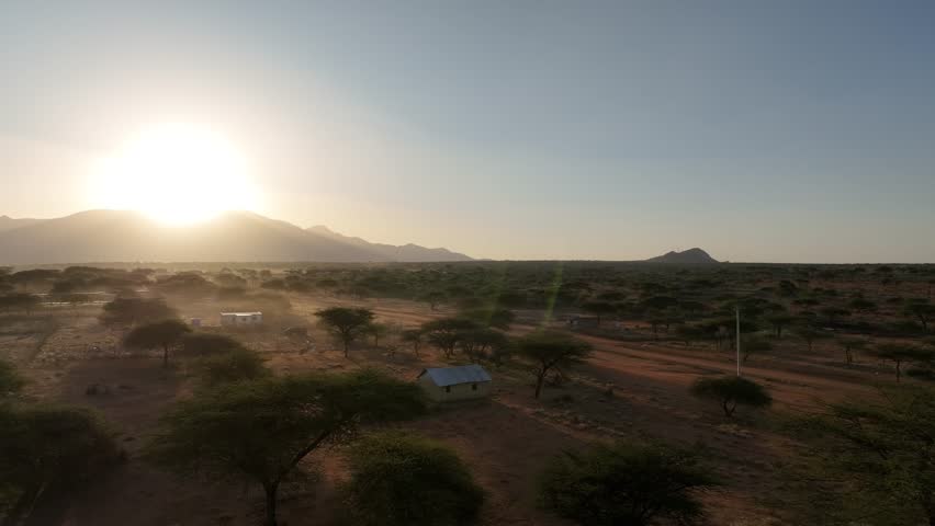 Aerial view of beautiful savannah landscape at sunset with trees and mountains under a vast sky, Wamba, Samburu, Kenya.
