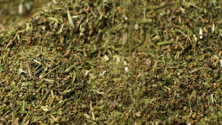 Culinary savory dried herb seasoning pour slow motion