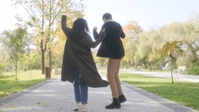 This fall scene shows a young couple dancing on a park path, radiating happiness and love. Surrounded by colorful leaves, they embrace the beauty of autumn. - Powered by Shutterstock - Get 15% off with code: PIKWIZARD15