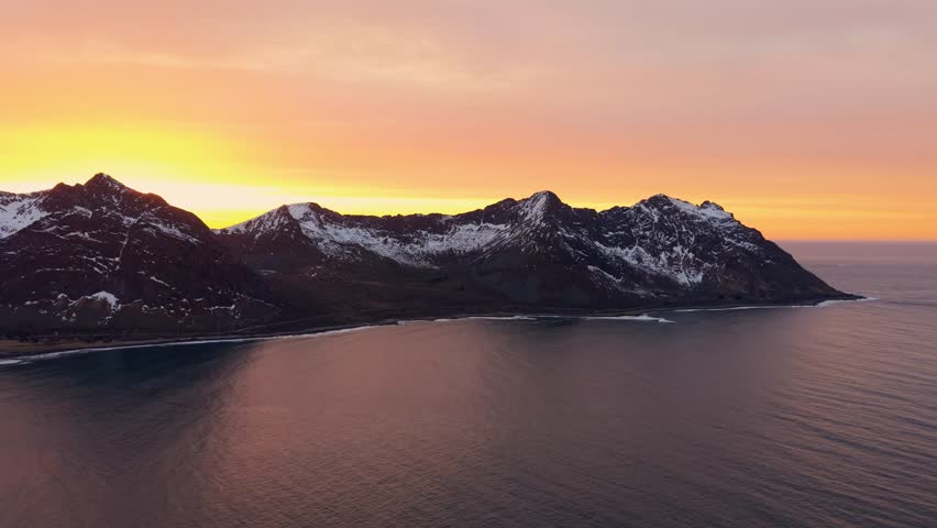 Golden sunset over a fjord in Norway, aerial view of rugged mountains and calm waters