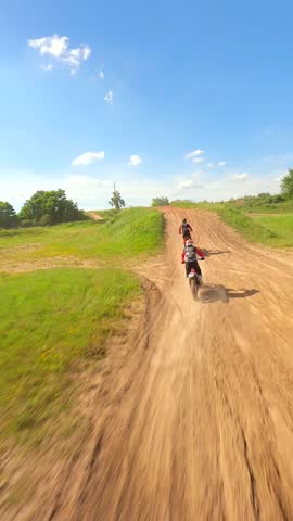 FPV drone shot of motocross racers on dirt track in slow motion. Concepts of extreme sports, adrenaline, and racing.