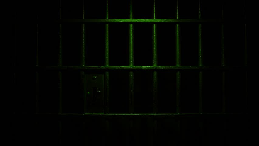 Prison Cell Bars Casting Shadows: Symbolizing Confinement and Loss of Freedom. metal prison cell bars casting shadows on the floor, representing themes of incarceration, confinement