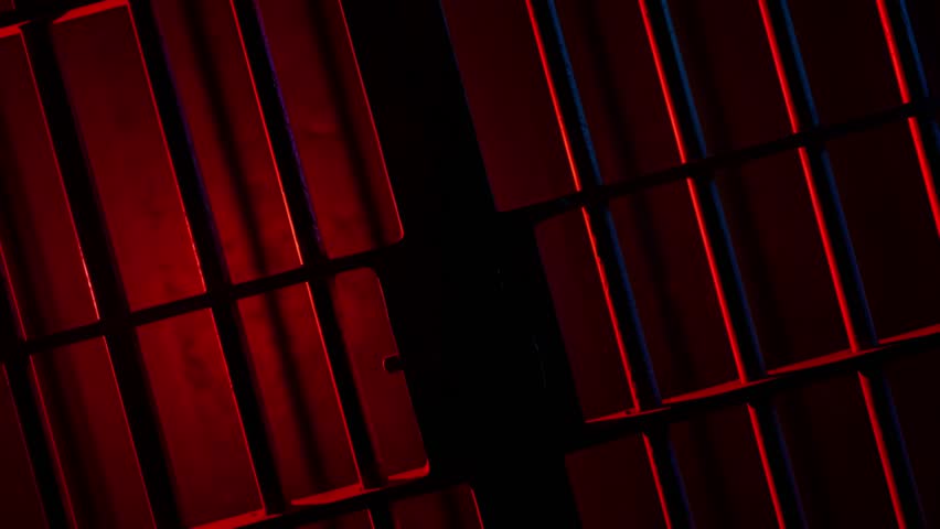 Prison Cell Bars Casting Shadows: Symbolizing Confinement and Loss of Freedom. metal prison cell bars casting shadows on the floor, representing themes of incarceration, confinement