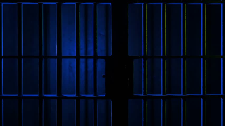 Prison Cell Bars Casting Shadows: Symbolizing Confinement and Loss of Freedom. metal prison cell bars casting shadows on the floor, representing themes of incarceration, confinement