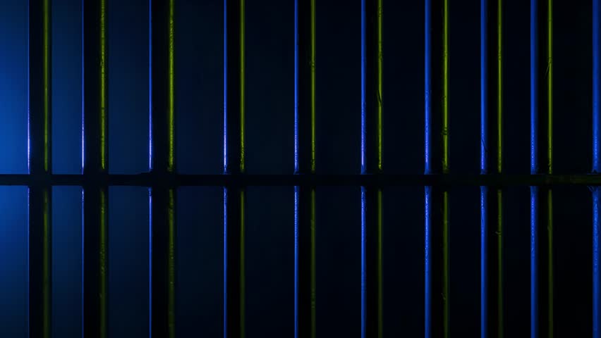 Prison Cell Bars Casting Shadows: Symbolizing Confinement and Loss of Freedom. metal prison cell bars casting shadows on the floor, representing themes of incarceration, confinement