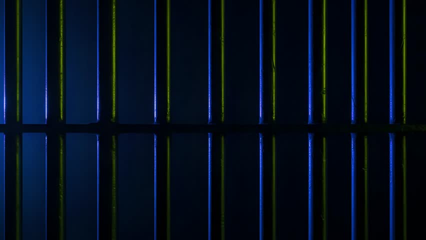 Prison Cell Bars Casting Shadows: Symbolizing Confinement and Loss of Freedom. metal prison cell bars casting shadows on the floor, representing themes of incarceration, confinement