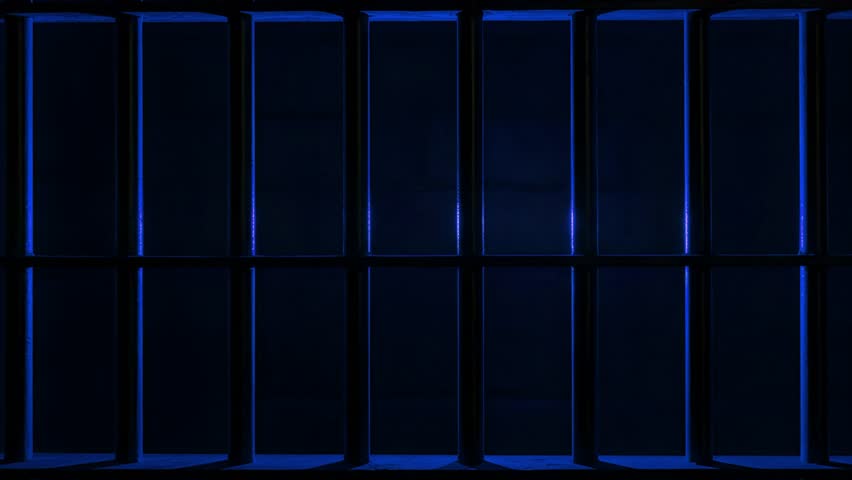 Prison Cell Bars Casting Shadows: Symbolizing Confinement and Loss of Freedom. metal prison cell bars casting shadows on the floor, representing themes of incarceration, confinement