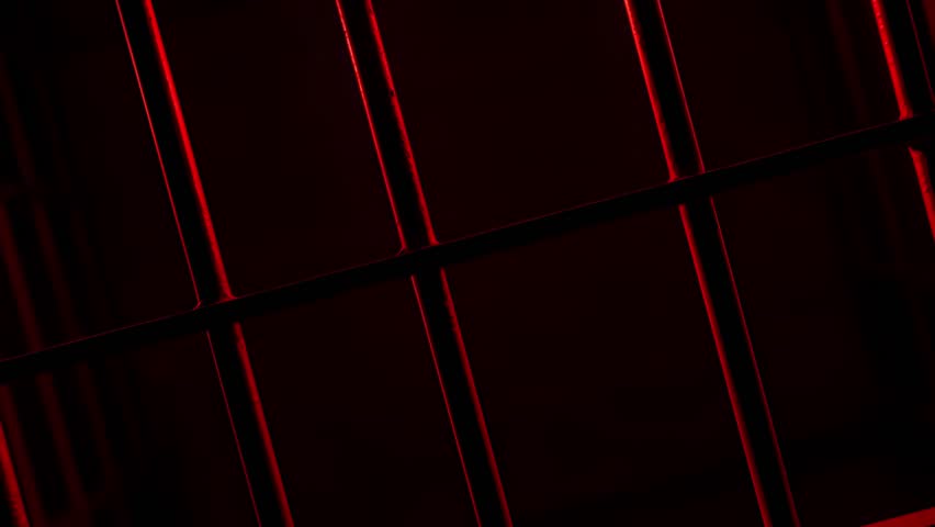 Prison Cell Bars Casting Shadows: Symbolizing Confinement and Loss of Freedom. metal prison cell bars casting shadows on the floor, representing themes of incarceration, confinement