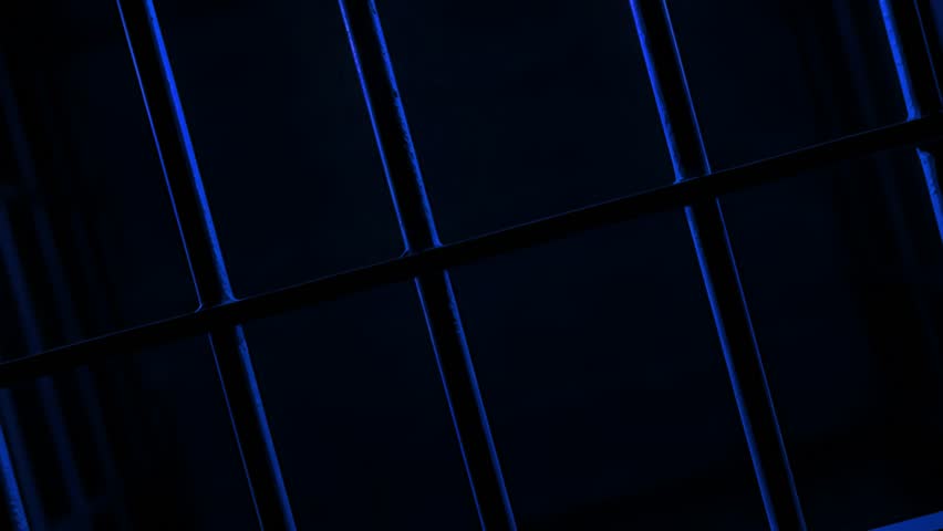Prison Cell Bars Casting Shadows: Symbolizing Confinement and Loss of Freedom. metal prison cell bars casting shadows on the floor, representing themes of incarceration, confinement