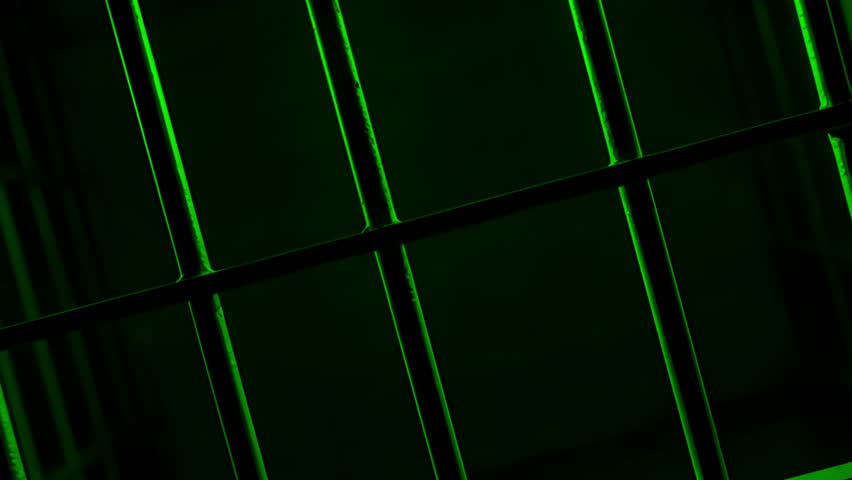 Prison Cell Bars Casting Shadows: Symbolizing Confinement and Loss of Freedom. metal prison cell bars casting shadows on the floor, representing themes of incarceration, confinement