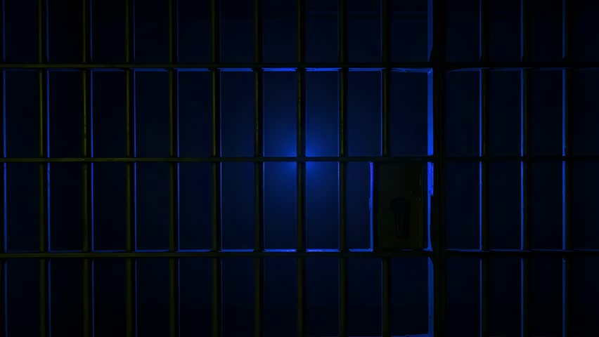 Prison Cell Bars Casting Shadows: Symbolizing Confinement and Loss of Freedom. metal prison cell bars casting shadows on the floor, representing themes of incarceration, confinement