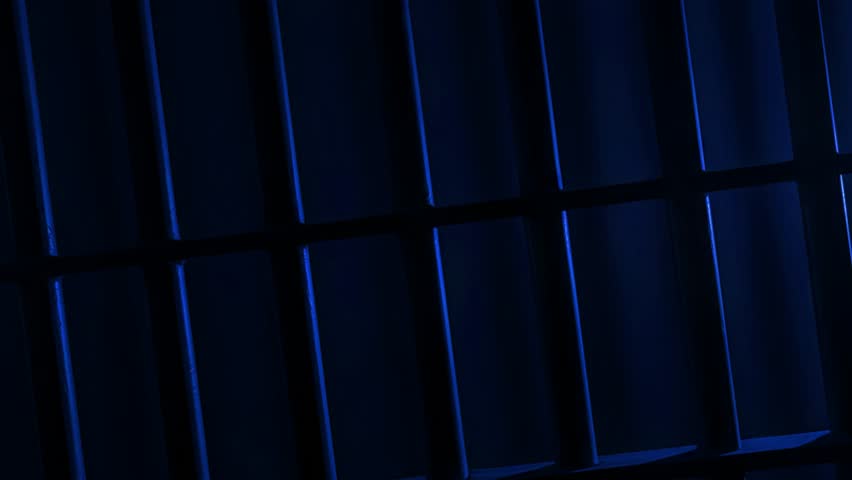 Prison Cell Bars Casting Shadows: Symbolizing Confinement and Loss of Freedom. metal prison cell bars casting shadows on the floor, representing themes of incarceration, confinement