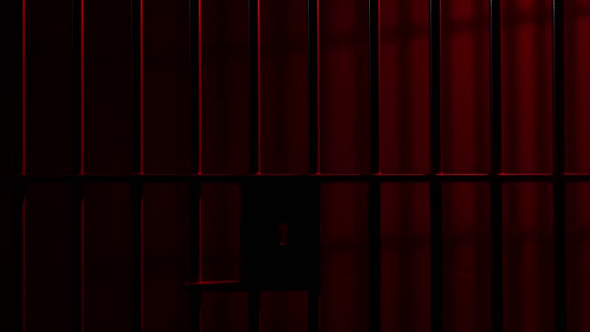 Prison Cell Bars Casting Shadows: Symbolizing Confinement and Loss of Freedom. metal prison cell bars casting shadows on the floor, representing themes of incarceration, confinement