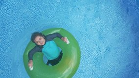 The summer kids. A kid floating on pool float in the swimming pool. A kid happily swimming in the home pool on a sunny day. A child relaxing on float in a sparkling swimming pool. Kid rest in water. - Powered by Shutterstock - Get 15% off with code: PIKWIZARD15