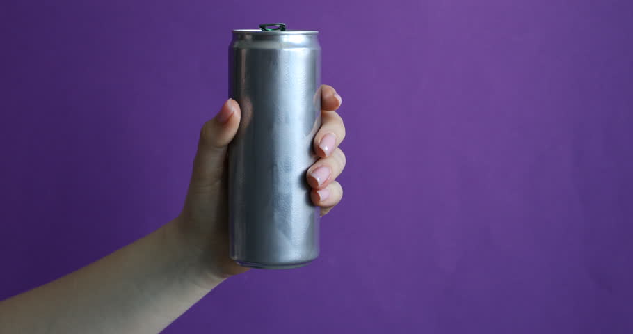 Woman crushing aluminium can on purple background, closeup. Space for text