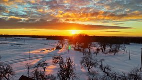 Wide angle drone shot of sunrise over snowy countryside with scattering of light in sky. Naturescape. - Powered by Shutterstock - Get 15% off with code: PIKWIZARD15