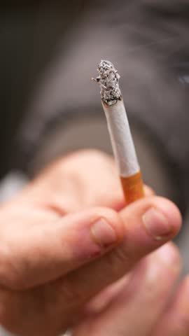 A Detailed CloseUp Image of a Hand Firmly Holding a Smoking Cigarette during an Intimate Moment