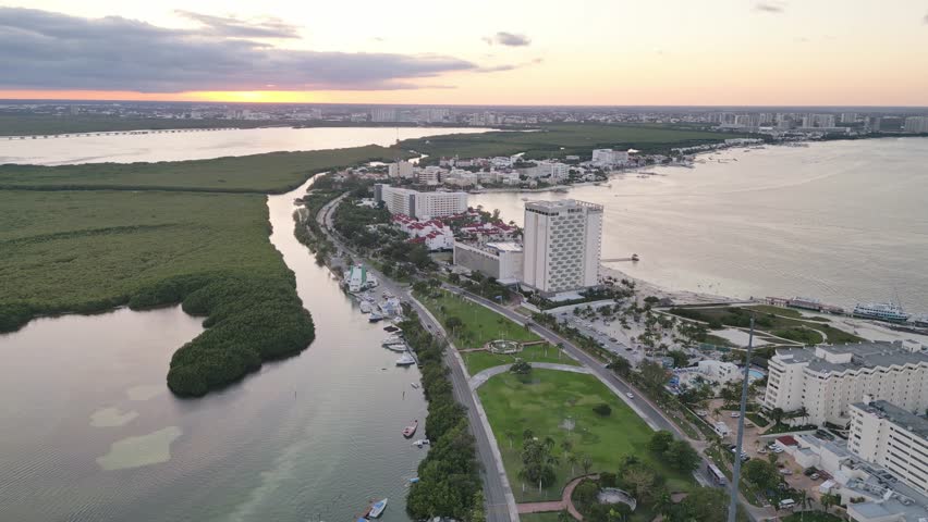 Cancun at sunset, featuring hotels, a lagoon, and a coastal skyline , aerial view
