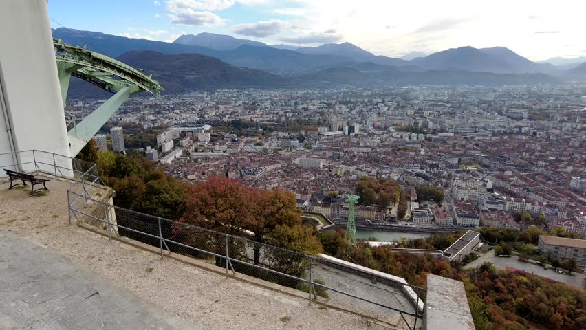 Panning video of Grenoble, France, showcasing the city, Is�re River, surrounding mountains, and urban landscape from an elevated viewpoint.