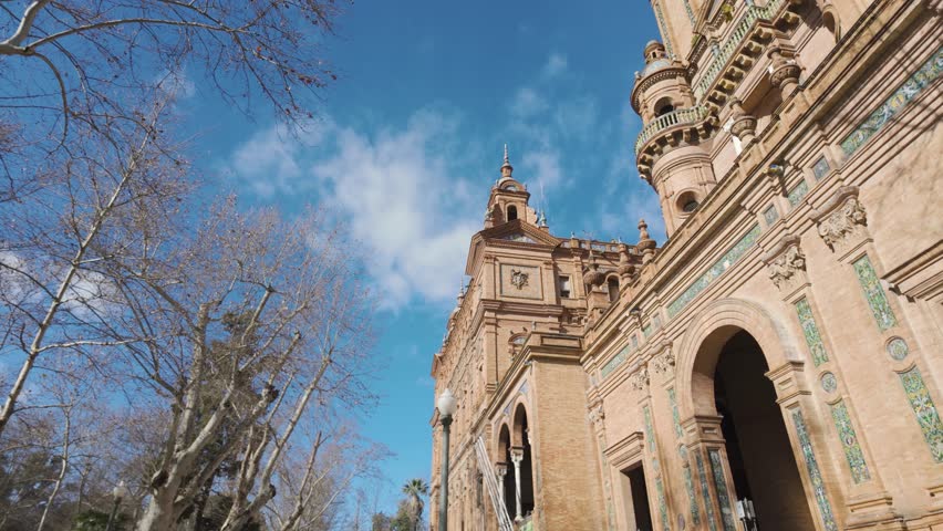 Low angle of the ornate tower of Plaza de España against a blue sky in Seville, Spain