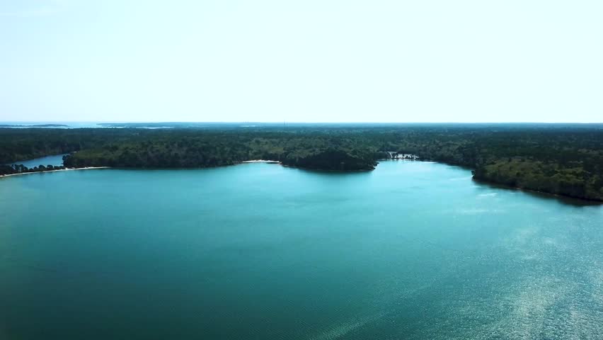 Aerial forward view of a wild coastline in a blue sea. Nickerson Park