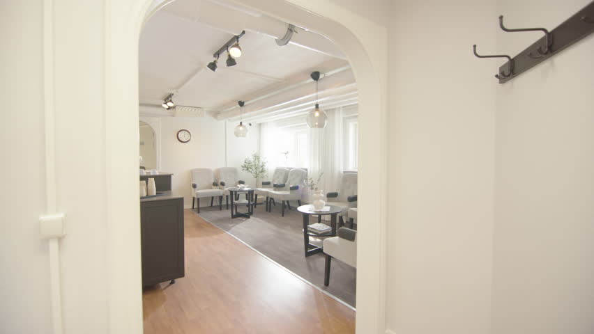 POV walking into stylish waiting room of health centre with receptionist