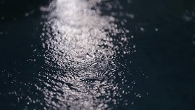 Raindrops hitting a dark pond, creating mesmerizing ripple patterns on the water's surface, slow motion - Powered by Shutterstock - Get 15% off with code: PIKWIZARD15