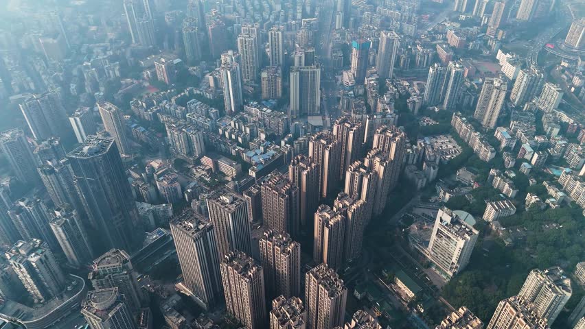 Aerial view of a densely packed residential area in Chongqing, China, showcasing high-rise apartment buildings. The city’s vast urban development and dense housing structures highlight rapid growth.