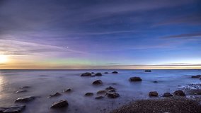 Timelapse. Scenic seashore with a boulders under a starry sky with the northern lights at dawn. - Powered by Shutterstock - Get 15% off with code: PIKWIZARD15