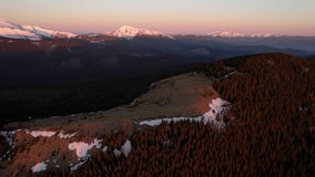 Aerial view of breathtaking mountain landscape at dawn, featuring snow-capped peaks against pastel pink and blue sky. Dense, dark forests cover the lower slopes. Carpathians, Ukraine. - Powered by Shutterstock - Get 15% off with code: PIKWIZARD15