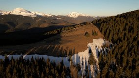 Aerial view of breathtaking mountain landscape at dawn, featuring snow-capped peaks against pastel pink and blue sky in the morning. Dense, dark forests cover the lower slopes. Carpathians, Ukraine. - Powered by Shutterstock - Get 15% off with code: PIKWIZARD15
