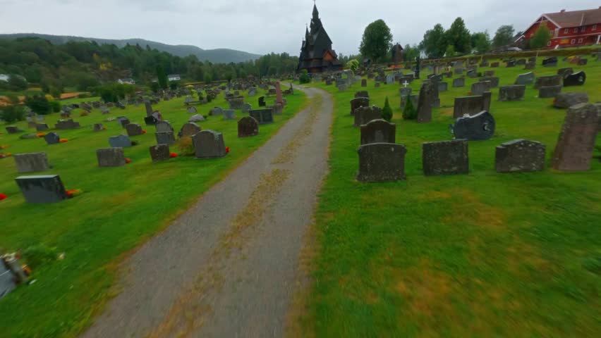 A dark, traditional norwegian building surrounded by scenic nature, aerial view
