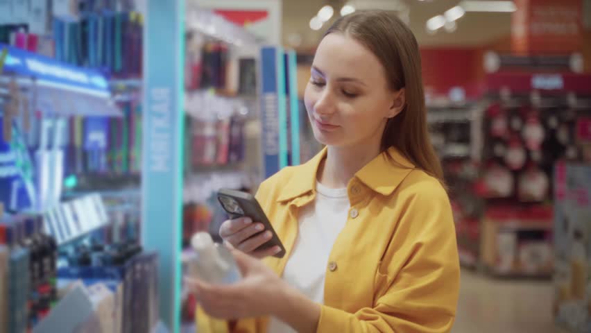 A person scans various micellar water products on the shelf while shopping at a retail store. The atmosphere is bright, showcasing numerous beauty items displayed for selection.