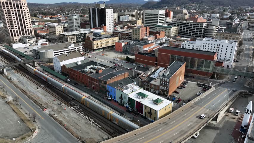 Roanake Cityscape with downtown buildings and skyline at sunny day. Aerial top down flyover. American town in Virginia, USA. Train on track near station. Financial district of city, USA.