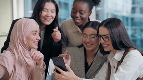 Excited joyful happy multiethnic women females diversity team five girls coworkers businesswomen business colleagues looking mobile phone discussing online app startup shopping social media in office - Powered by Shutterstock - Get 15% off with code: PIKWIZARD15
