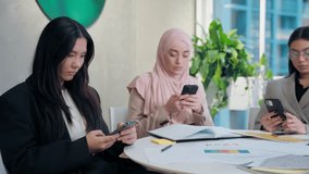 Multiethnic women females diversity team girls group coworkers businesswomen online browsing mobile phone overuse smartphone distraction gadget addiction cellphone social media in office meeting room - Powered by Shutterstock - Get 15% off with code: PIKWIZARD15