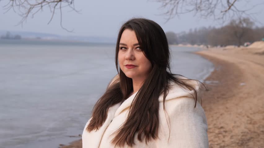 Smiling woman enjoying winter day on the beach