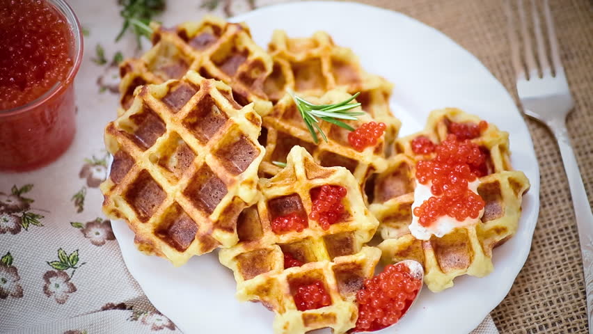 Homemade potato waffles with caviar and herbs for breakfast.