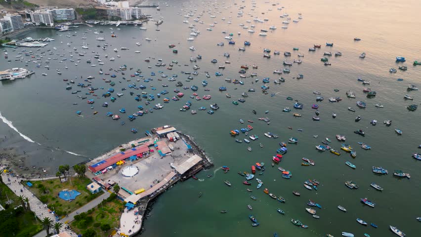 Golden hour at Ancon Beach, with silhouettes of fishing boats drifting on calm ocean waters.