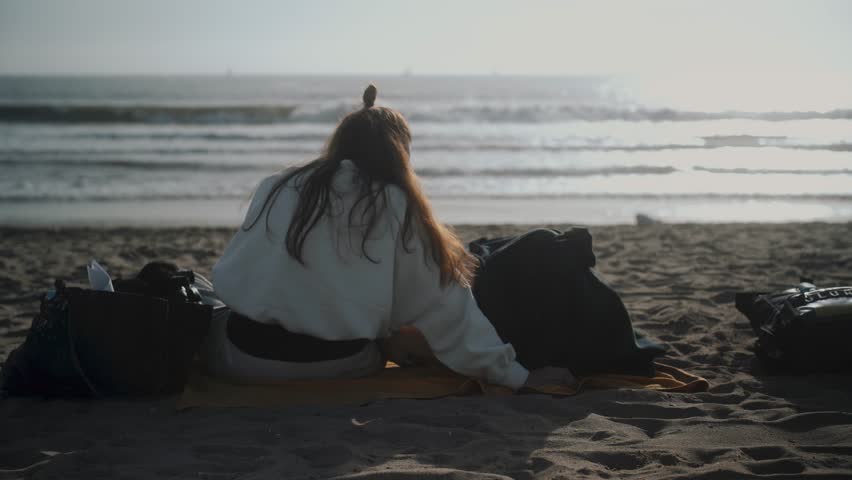 Mother and Child Relaxing on a Beach at Sunset