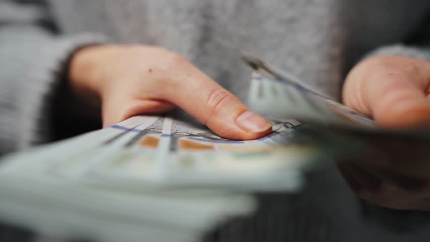 Woman counting US Dollar bills, close-up